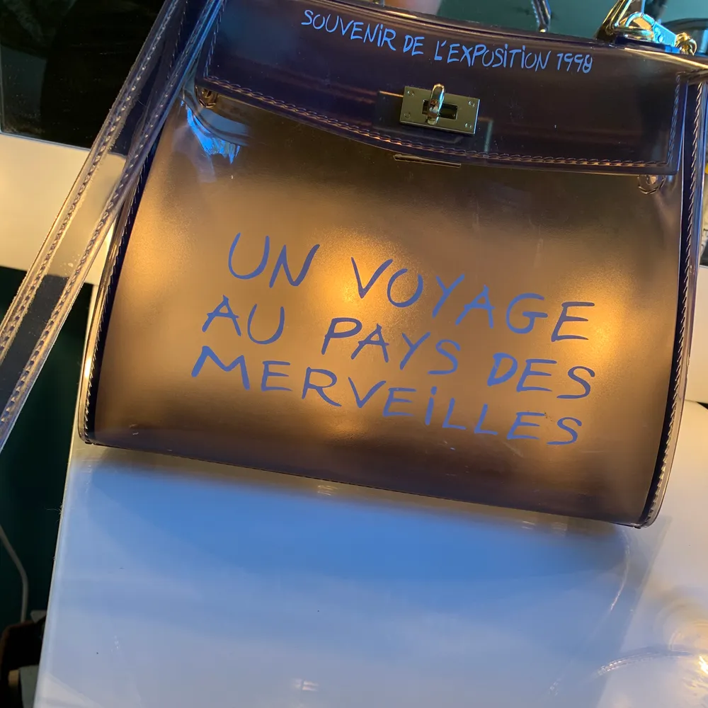 Fin väska som är genomskinlig och har text på franska, knappt använd . Väskor.