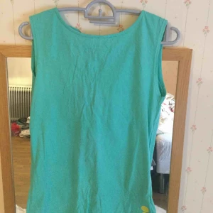  - En grön T-shirt med hål bakom 