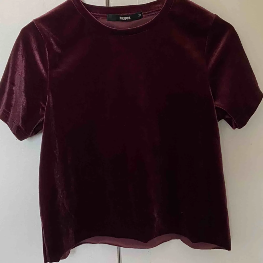 Vinröd t-shirt i sammet från BikBok. Storlek XS men passar även S :) Modellen är avklippt längst ner😊. T-shirts.