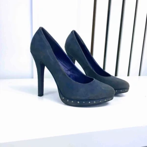  - Blålila pumps med små runda metalldetaljer. Klack: 13 cm.  (Swish-betalning: Finns i Rissne/köparen står för frakten.)