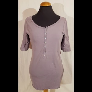 Ljus lila tröja 38/40 redoute - La Redoute Active Wear, Storlek 38/40. Lång tröja, ljuslila med 3/4 ärmar. Fin spets mellan knapparna.