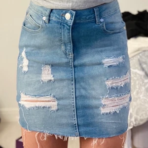 Jeanskjol med slitningar  - Jättefin jeanskjol med slitningar, aldrig använd.             Väldigt stretchig så den passar enkelt XS/S och M.       Kontakta mig vid mer frågor eller bilder