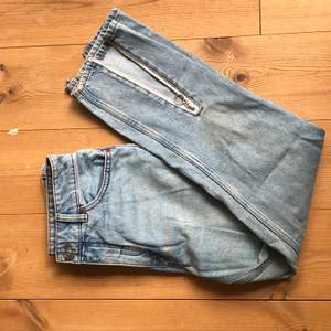 Ljusa jeans med slitsar/dragkedjor nedtill. Köparen står för frakt 