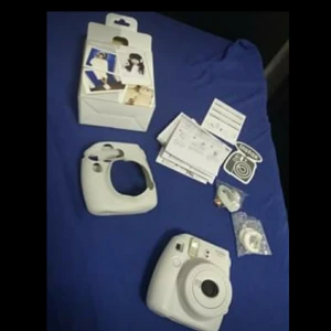 Kamera fujifilm - Vi säljer en kamera som kan ta ut bilder och ser innebär att med hela paketet så finns det två linser, ett band som man kan hänga den med, skal, klistermärke, instruktioner och själva paketet. Den år i bra skick men man måste köpa papper till den.