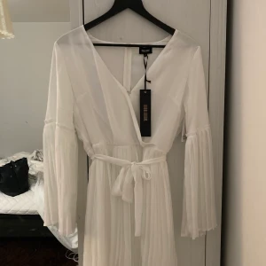 Vit långärmad sommar klänning  - Oanvänd, prislappen sitter kvar. Storlek 38, från bubbelroom, stämmer i storlek. Ny pris 499kr. Kunden står för frakten 