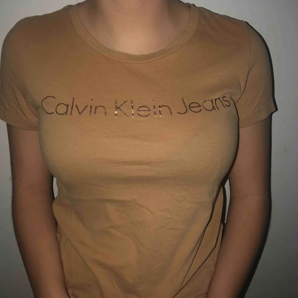 Beige Calvin Klein t-shirt i strl XS. Använd 1 gång och i mycket gott skick. Köparen står för frakten och pris kan diskuteras.. T-shirts.