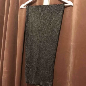  - Snygg långkjol i glittrigt och stretchigt material. Resår i midjan. 