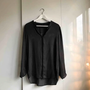  - Mörkgrå blus från H&M. Små diskreta prickar i tygmönstret.    Köparen står för eventuell portokostnad. 
