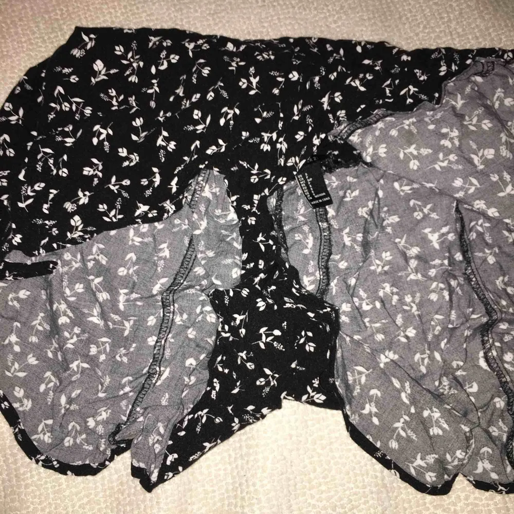 Svart blommönstrat shorts med ett elastiskt band, som ser ut som en kjol från forever 21. Kjolar.