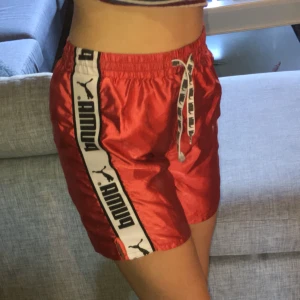  - Sportiga Puma-shorts i glansigt material, väldigt gott skick, förutom att på ett av snörena har slutdubben fallit av, men själva byxan består intakt