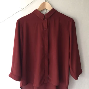 - Mörkröd blus av polyester! Är en M men är ganska tight så passar nog bättre på en S. Väldigt lätt och sval, fin till sommaren! (Frakt +35kr)