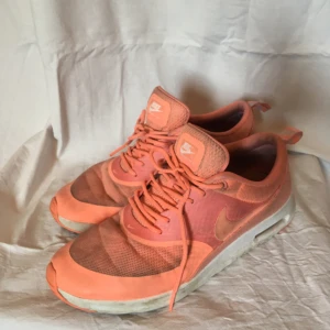  - Nike air max thea sneakers i persikofärg. Använda men fortfarande hela, endast lite smuts ;-). Kan ej hitta strl men skulle säga att det är en liten 40 eller vanlig 39a.  Köpta för 1200