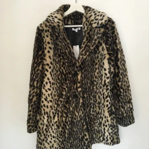  - Oanvänd kappa i fuskpäls från Moss Copenhagen. Nypris: 1250kr. Säljes för 200kr.