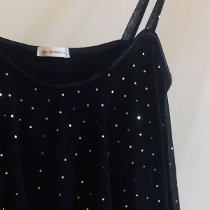  - IDA SJÖSTEDT   Storlek S 100% poly 80% viscose 20% spandex Svart + guld paljetter  Klänning (går strax över knäna på mig 163 cm) Fint skick, använd några fåtal ggr Nypris 2000 kr