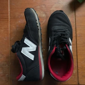  - Snygga rödsvarta new balance-skor. Inte direkt slitna men definitivt i använt skick. Gummit har släppt lite på högra skon men det syns inte egentligen. Så sköna! Lite stora i strl. 