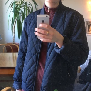  - Blå jacka liknande en bomberjacka! Uppskattad storlek till M. Jättefint skick, och superskön. Frakt tillkommer om inte möte i Sthlm bestäms. 