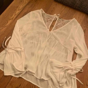  - Fin blus från H&M med spetsdetaljer.  Knappt använd, men storlekslappen avklippt pga skav.  Köparen betalar frakten