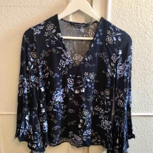  - Fin blommig blus med volang på ärmen. 
