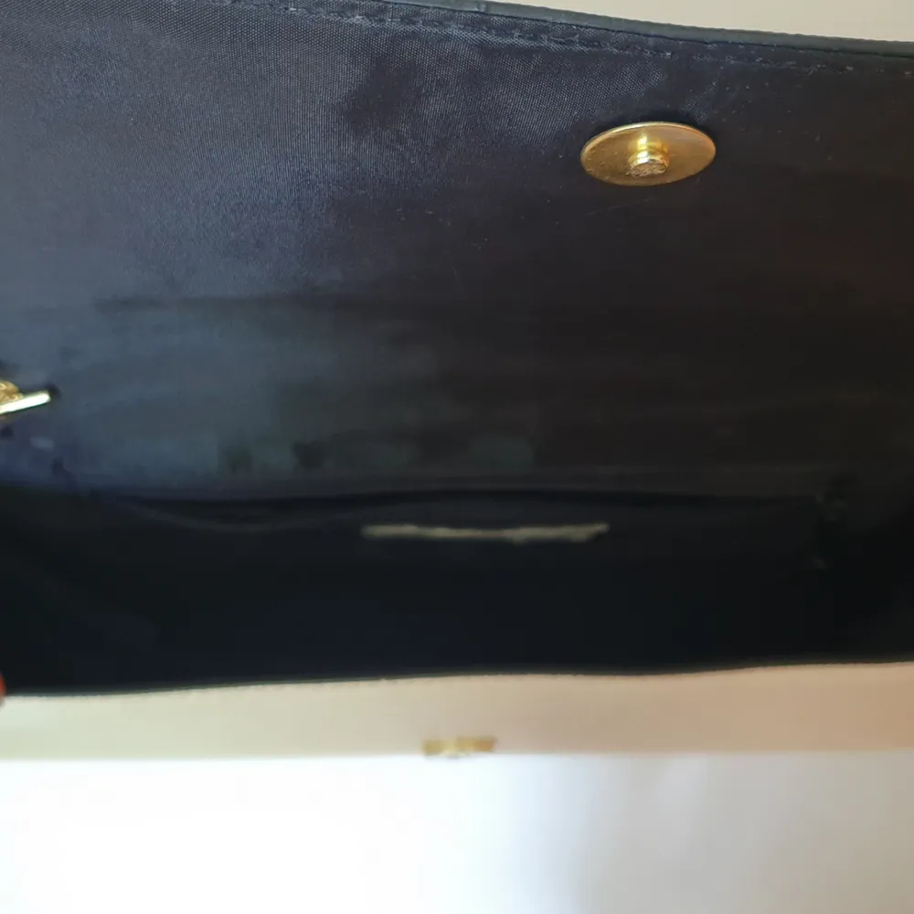 Benvit handväska med guldkedja. Lite smutsig på ovansidan (se bild 2). Ett stort fack samt ett litet innefack. Frakt tillkommer. . Väskor.
