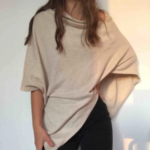  - Skitsnygg och mysig beige poncho från black story. Tunt stickad. Passar med allt. Mycket fin med någon enfärgad långärmad tröja under! Säljer pga att den tyvärr inte kommer till användning
