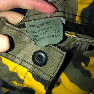 Camouflage byxa - Använda ett fåtal gånger! Finns snören så man kan dra åt dem vid bena och 6 fickor som är väldigt rymliga. Dessa är ganska så stora i storleken så kan vara välbehövligt med ett skärp till, så dem sitter snyggt! :D                                  En i storlek M kan säkerligen ha dessa med! 
