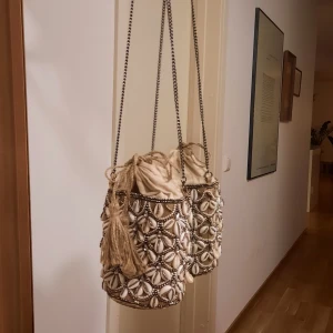 Zara väska, snäckor - En söt väska från zara, perfekt storlek eftersom den är som en liten säck inuti. Nypris 559:- fint skick alla snäckor och diamanter finns! Pris ex porto