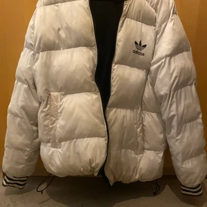 Svart och vit Adidas puffer vändbar jacka  - Använt skick. Oklar storlek, men ca M. Jag är 174 cm sitter till rumpan 