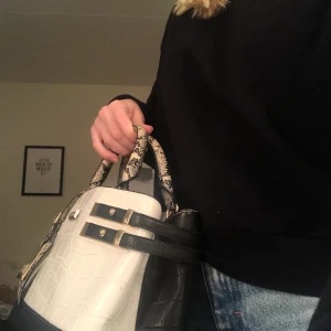 Väska  - Väska från River Island. Inte för stor men heller inte för liten. Flera stycken fack inuti. Kan mötas upp i Slussen eller Nacka forum. 