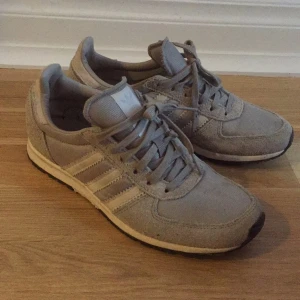  - Grå adidas sneakers med mockadetaljer