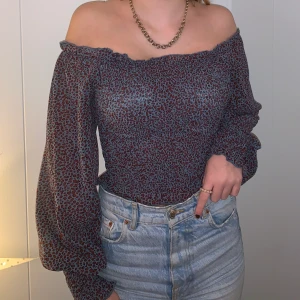 Blus  - Gullig blus med långa ärmar som ja köpt på kings&queens i malmö. Superfint blått och lila mönster och man kan den båda off sholder och med axlarna på. Köparen står för frakten.