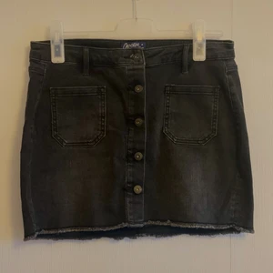 Jeanskjol  - Grå/svart kjol med knappar och fickor.