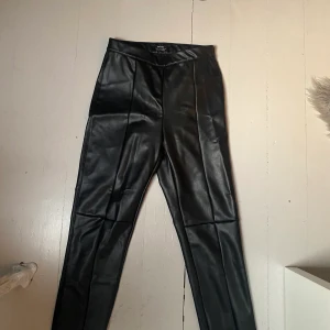 Fake skinnbyxor  - Säljer mina fake skinnbyxor från Bershka, så fina🥰 Aldrig använda så dom är i nyskick. Dom har en silverdragkedja på sida och väldigt fina detaljer framtill, kontakta för fler bilder! 