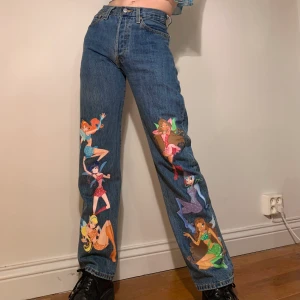 Custom vintage Levi’s 501 raka jeans Winx Club Y2k tryck - (För egna custom jeans var inte rädd att kontakta mig via min instagram: lukasmedailleu❤️) Inte säker på om jag vill sälja, så buda i kommentarerna + skriv privat, startar från 500kr, men vill du garantera att du får denna gem ligger KÖP DIREKT på 1100kr‼️HÖGSTA BUDET: 850kr‼️Raka vintage Levi’s 501 jeans med handgjort Winx Club tryck av textilfärg på framsidan av båda byxorna 🧚🏼‍♀️ Går att ha som både hög- och lågmidjade! Alla 6 ikoniska feerna är med på dessa vintage jeans med så snygg passform; de är raka vilket ger en skön fit men samtidigt sitter de asbra över rumpan och låren! I och med alla de härliga färgerna (både pasellnyanser men även några starkare) går de att matcha vad som helst! Allt ifrån en vit tajt baby tee till en galen färgglad mesh tröja, båda blir en sån Winx vibe! (Också hur snygga som helst med ett par plattform skor för att verkligen fånga essencen av Winx Club!) Mått: midjemått: 69 cm, byxlängd: 104 cm, innerbenslängd: 80 cm 