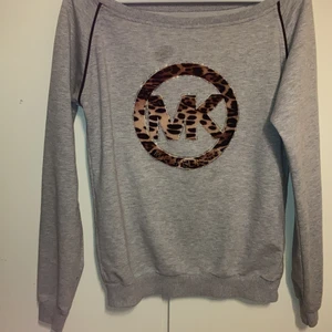 Tröja - 🤎Säljer denna oäkta michael kors tröjan då det inte är min stil längre. Den har en fläck ovanför märket (som ni ser på andra bilden) som jag inte tror går bort. Den har även små färg fläckar som inte går bort som syns på andra bilden. Annars är det en super fin tröja.                                                              🤎 Det finns inte någon lapp i den men skulle säga att det är som en XS/S möjligtvis även M beroende på hur man vill att den ska sitta.                                    📦 Köparen står för frakten.