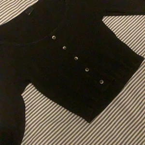 Magtröja.  - Ribbad magtröja med fejkade knappar, går alltså inte att öppna.  Lite liten i storleken så passar nog mer M och S. passar självklart L också men tycker den är lite tajt i armarna. 