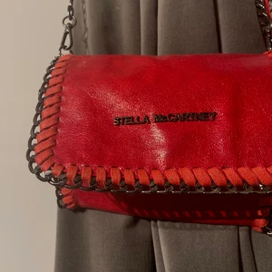 STELLA McCARTNEY AXELVÄSKA - En röd nästan oandvänd Stella McCartney axelväska, jag har inget bevis på att den är äkta då jag fick den utav min moster. Vill bli av med den så kan gå med på nästan vad som helst!