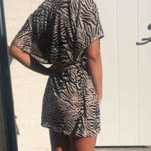  - Helt oanvänd klänning! Passar alla storlekar beroende hur en vill ha den då bandet knyts själv 