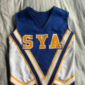  - Vintage cheerleadertröja, hittat på second hand. Använd ett fåtal gånger. Mycket stretchigt material, är lite som en lång magtröja.