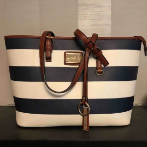  - Handväska, säljer för att jag inte är ett stort fan av handväskor längre 😌 stängs med en dragkedja och har mindre fack inuti, rymmer saker som drickor, ombyte och annat. Perfekt till skolan då den också rymmer en mindre skoldator! Frakt tillkommer