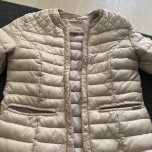 En beige dunjacka  - Knappast använd, säljer pga storlek. Kontakta för fler bilder och/eller frågor. Köp gärna!!