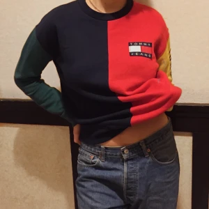 Färgglad äkta Tommy Hilfiger sweater - En äkta sweater från Tommy hilfiger i röd, gul, grön och blå. Loggan sitter på vänstra bröstet och det står även Tommy hilfiger på vänstra armen. Jättesnygg men säljer eftersom den är lite för liten för min smak. Använd endast ett fåtal gånger. Originalpris var 1400 kr. Kontakta mig vid intresse kanske blir budgivning. Frakt tillkommer eller mötas på Södermalm!:)