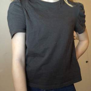 En svart/mörkgrå t-shirt med puffärmar från h&m i strl xs, sällan använd och i nyskick. Köparen står för frakten🤍