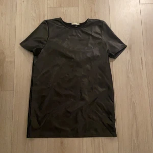 Skinn klänning - En skinnklänning från Nelly i storlek XS, ganska kort i modellen
