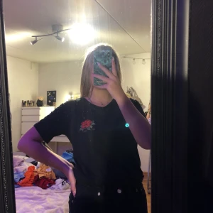 Svart T-shirt  - Svart T-shirt med en påsydd ros från lager 157 säker för 160 och då inkluderas frakten 