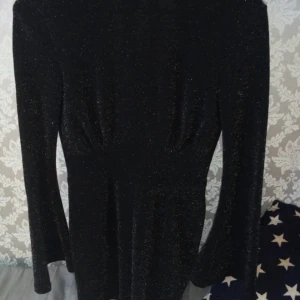 Playsuit - Svart playsuit med glitter! Aldrig använd, lappen är kvar. Tänkt att ha till nyår förra året men hittade annat. Den har en öppen rygg med knytning i nacken! Super häftig😍