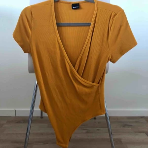  - Senapsgul body från Gina Tricot i strl L.
