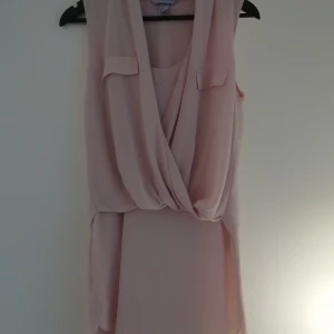 Klänning - Ljusrosa klänning med tunt tyg över bröstet 