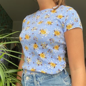 Blommig ljusblå t-shirt - 🌜OBS! Många som gillat men knappt någon som skrivit/lagt bud! Tröjan finns alltså fortfarande kvar för 80 kr + frakt🌛 Skön och stretchig t-shirt från Monki, passar storlek S. Tröjan är lite kortare i modellen men inte croppad. Frakt på 44 kr tillkommer 