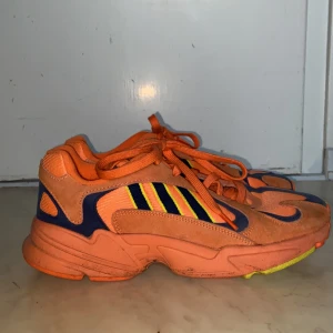 Orangea Adidas Yung 1 - Har knappt använt dessa skor och har haft dem i några månader. Väldigt sköna skor och i bra skick. Möts helst upp i Stockholm. Nypris 1200kr.Priset är förhandlingsbart:)