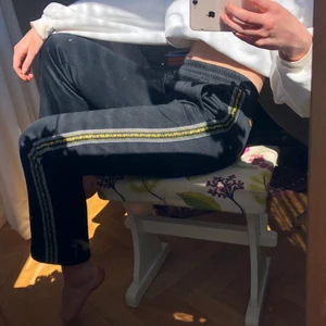 FILA byxor strl S - Byxor/sweatpants från FILA med guldiga och vita detaljer längs sidan av benen. Mina favoritbyxor men får knappt användning av dom längre. Kan mötas upp i Stockholm, kan annars frakta dom och köparen får stå för fraktkostnad.